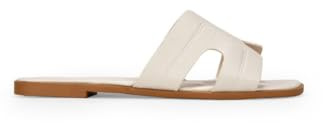 Sandalias planas estilo pala compuestas por una tira ancha decorativa en el empeine con aperturas laterales. Sin cierre.