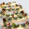 JOFONY Guirnalda de Navidad con iluminación decorativa, 2 m, 20 ledes, guirnalda de abeto, batería, blanco cálido, cadena de luces con piñas, bayas, campanas, decoración navideña para interior y