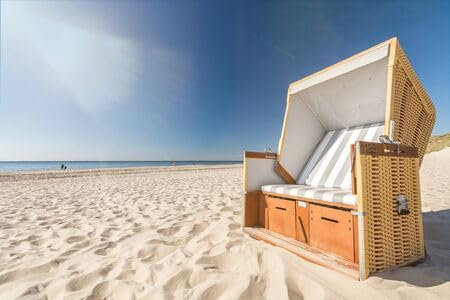 adrium Holz-Bild 140 x 90 cm: Strandkorb am Meer mit malerischem Lens Flare auf der Insel Sylt, Deutschland (133485704)