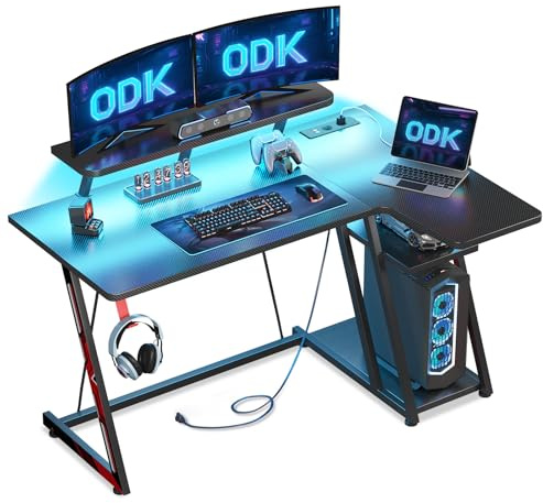 ODK Scrivania Gaming Angolare con Luci LED e Prese di Corrente, 120x70 cm Postazione Gaming con Supporto per Monitor, Scrivania Computer con Ripiano di Stoccaggio Fibra di Carbonio Nera