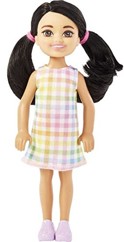 Barbie Chelsea-docka, liten docka med svart hår i pigtails och bruna ögon bär avtagbar rutig klänning och rosa skor